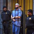 Officials escort "Serial" podcast subject Adnan Syed from the courthouse following the completion of the first day of hearings for a retrial in Baltimore on Wednesday, Feb. 3, 2016. (Karl Merton Ferron/Baltimore Sun/TNS via Getty Images)